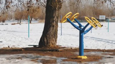 Sokak sporları simülatörleri. Açık hava spor sahası. Spor simülatörleriyle ıssız bir açık hava spor sahası, karla kaplı. Şehir plajı. güneşli kış günü.