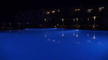 Geceleri yüzme havuzu. Havuz suyu, mavi arka plan, gece vakti.