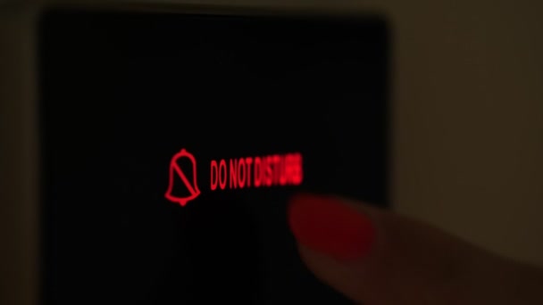 Do not disturb. close-up. the sign is lit in red. electronic plate. a digital board with an inscription - do not disturb, in the hotel room. female finger presses the button. — 图库视频影像