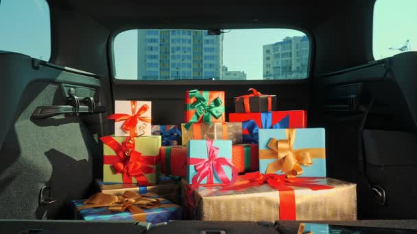 Geschenkboxen im Auto. Lieferservice. viele schön verpackte Pakete, Schachteln, liegen im Kofferraum, in der Sonne. Nahaufnahme, Blick aus dem Inneren des Autos. Spende, Wohltätigkeit. Online bestellen. Weihnachtsgeschenke — Stockvideo