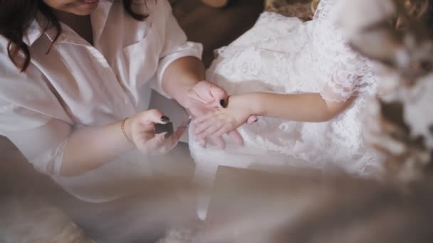 Paint kids nails. varnish kids nails. close-up. Mom daughter. cute little girl. mom and little daughter spend time together, have fun. mom paints her little daughters nails — 图库视频影像