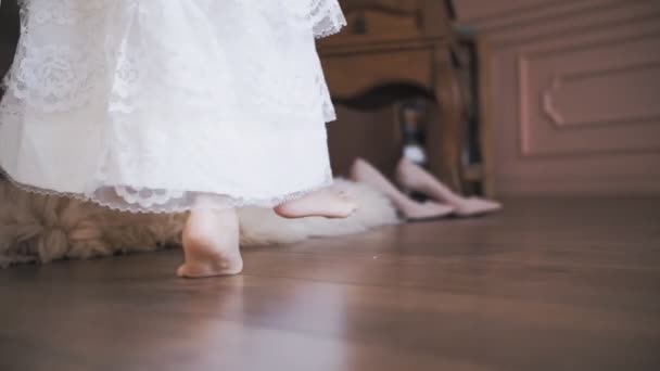 Linda niñita. Baile infantil. Primer plano. Princesa pequeña, en un vestido de encaje blanco como la nieve, bailes, giros, descalzo en la habitación. — Vídeos de Stock