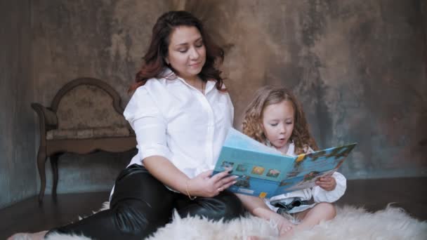 Child reads a book. mom daughter. cute little girl. mom and little daughter spend time together, read a book together, have fun. family — Vídeos de Stock