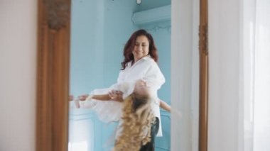 family. Mom and daughter. cute little girl. mom is circling her little Princess in white lace dress. mom and little daughter spend time together, have fun.