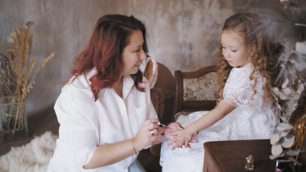 Spijkers voor kinderen schilderen. Vernis kinderen nagels. Mam en dochter. Leuk klein meisje. Mam en kleine dochter brengen tijd samen door, veel plezier. Moeder schildert haar dochters nagels, verkleedt de kleine prinses. — Stockvideo