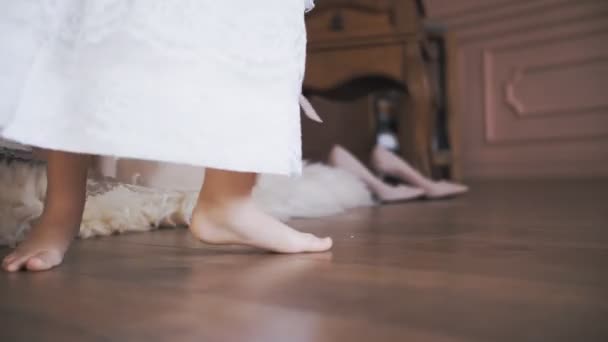 Cute little girl. kid dance. close-up. little Princess, in a snow-white lace dress, dances, whirls, barefoot in the room. — Vídeo de Stock