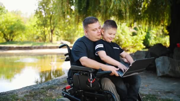 fathers day. dad and son. dad and little son spend time together, having fun. person with a disability. people with special needs. wheelchair user.