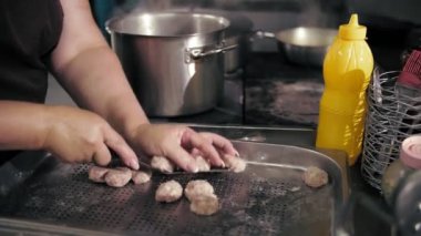 Yarı bitmiş et ürünleri. Yemek pişirmek. Yakın plan. Şef, yarı bitmiş et ürünlerini, donmuş köfteleri kaynar suya koyar. Ticari bir mutfakta yemek pişirmek..