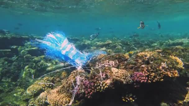 Vuilnis in de zee. Plastic vervuiling van de zee. gebruikte blauwe plastic zak langzaam drijvend onder water in de zon lichten. Achtergrondverlichting. Milieuverontreiniging door kunststofafval — Stockvideo