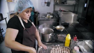 Yarı bitmiş et ürünleri. Yemek pişirmek. Şef, yarı bitmiş et ürünlerini, donmuş köfteleri kaynar suya koyar. Ticari bir mutfakta yemek pişirmek..