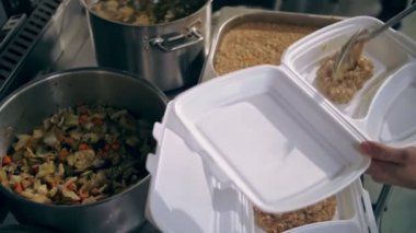 Bağışlar. Yemek pişirmek. Hayır işi. Yemek servisi. Hayır kurumları, halk çorbacıları fakir ve muhtaçlara bedava yemek hazırlıyor. Şef yemek kabına sıcak yemek koyar..
