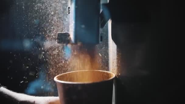 コーヒーグラインダー。接近中だ。コーヒー豆を自動コーヒーグラインダー機で挽いたコーヒー粉を粉砕する工程。バックライトで — ストック動画
