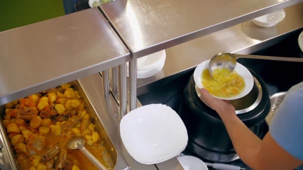Ресторан "шведський стіл". кафетерії самообслуговування. крупним планом. офіціантка, в захисних рукавичках, вливає гарячий суп в миску для клієнта. готувати. харчування для здоров'я . — стокове відео