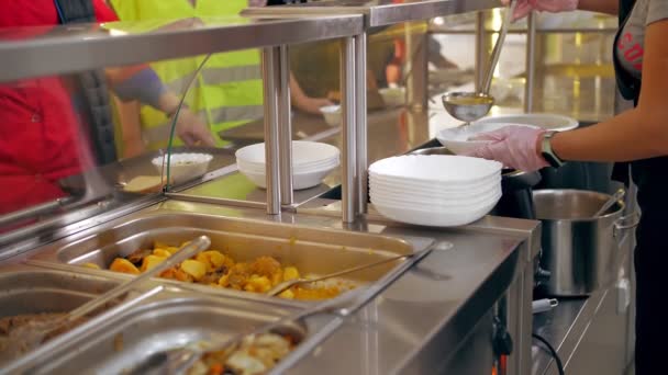 Restauracja bufetowa. samoobsługowa stołówka. zbliżenie. kelnerka, w rękawiczkach ochronnych, wlewa gorącą zupę do miski dla klienta. gotowanie. żywność dla zdrowia. — Wideo stockowe