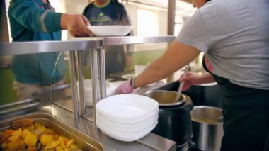 Açık büfe restoranı. Kendi kendine hizmet veren kafeterya. Yakın plan. Garson, koruyucu eldivenler içinde, müşteri için sıcak çorbayı kaseye dolduruyor. Yemek pişirmek. sağlıklı gıda.