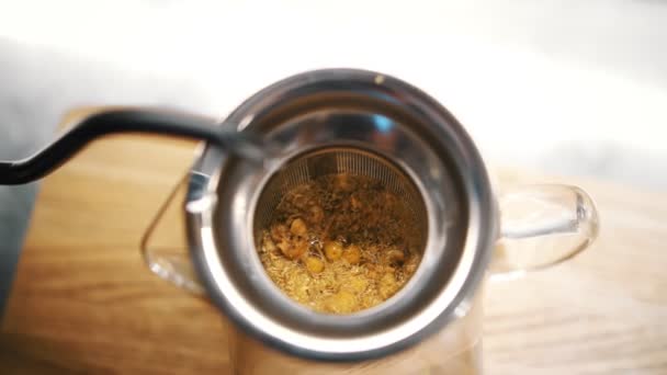 Τσάι από βότανα. Τσάι ποτό. προετοιμασία τσάι από βότανα. Κοντινό πλάνο. Στην κορυφή. διαδικασία παρασκευής χαμομηλιού. το ψιλοκομμένο ξηρό χαμομήλι χύνεται με βραστό νερό σε τσαγιέρα — Αρχείο Βίντεο