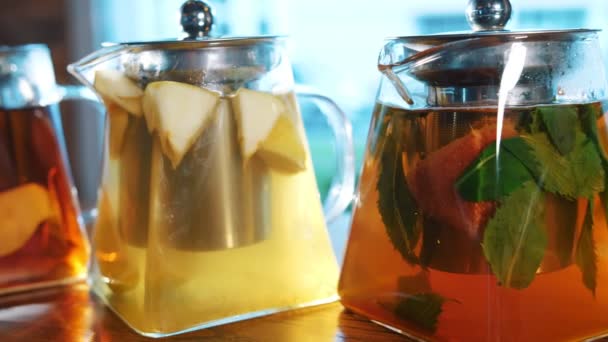 Fruit tea in a teapot. herbal tea. tea drink. close-up. three glass teapots with different fruit and herbal, colorful, homemade teas. — Stock Video