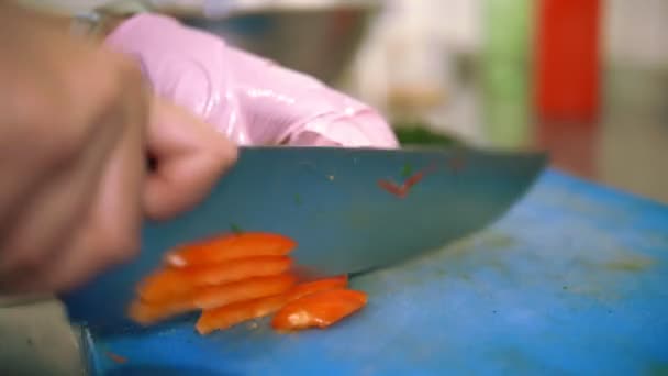 Yemek pişirmek. Şef sebze keser. Açık büfe restoran mutfağı. Yakın plan. Şef, plastik tahta üzerinde keskin, büyük bir mutfak bıçağıyla taze çan biberini küçük parçalara ayırıyor.. — Stok video