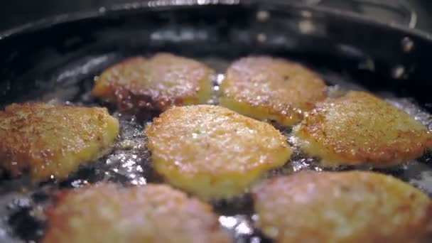 Latkes de batata. Patty de batata. cozinhar. Bolos de batata, Zélix. cozinha restaurante buffet. close-up. O cozinheiro está lançando latkes de batata crocante, fritando em óleo sizzling. — Vídeo de Stock