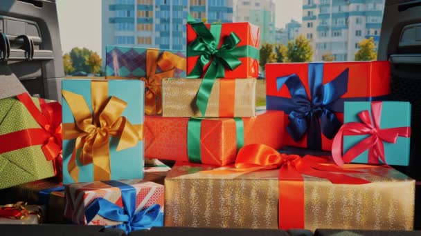 Подарункові коробки в машині. служба доставки. багато красиво загорнуті посилки, коробки, лежать у багажнику автомобіля, на сонячних променях. крупним планом, вид зсередини машини. пожертвування, благодійність. Онлайн-замовлення. різдвяні подарунки — стокове відео