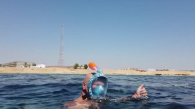 Şnorkelle yüzmek. Yüzme. Dalış. Şnorkel maskeli bir adam sayısız resif balığıyla sualtı mercan resiflerini keşfediyor. Yüzme alanının genel görünümünü gösteriyor..