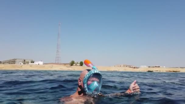 Fare snorkeling. Nuoto. immersioni. un uomo, in maschera da snorkeling, sta esplorando la barriera corallina sottomarina con innumerevoli pesci della barriera corallina. Mostra una panoramica della zona nuoto. — Video Stock