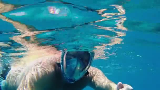 Šnorchlování. Plavání. potápění. muž v šnorchlovací masce zkoumá podvodní korálové útesy s nespočetnými barevnými, exotickými, útesovými rybami. — Stock video