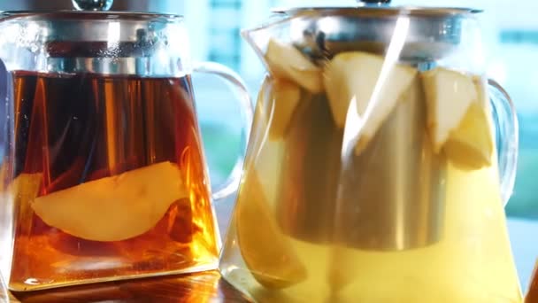 Früchtetee in einer Teekanne. Kräutertee. Teetrinken. Nahaufnahme. drei gläserne Teekannen mit verschiedenen Früchten und Kräutern, bunte, hausgemachte Tees. — Stockvideo