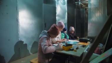 Ukrayna 'da savaş. Sığınak. Çocuklar bodrumda bir sığınakta saklanıyorlar, hava alarmı sırasında, roket ateşi. Çizim yapıyorlar. Rus istilası. Savaşı durdurun. Savaş Yok.