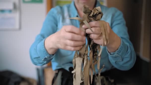 Military Camouflage Net Sewing Volunteer Demonstrates Self Made Khaki Tissue — Stock Video