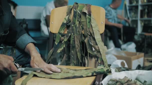 Naaien Een Kaki Camouflage Net Vrijwilliger Snijdt Camouflage Stof Linten — Stockvideo