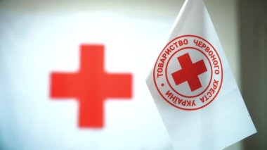 white flag with red cross emblem. close-up. Red Cross. international charity organization offers, provides poor people with humanitarian aid and social donations.