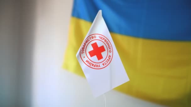 White Flag Red Cross Emblem Close Background Blue Yellow Flag — Αρχείο Βίντεο