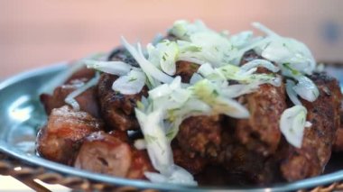 Lula Kebap. Yemek pişirmek. Şişte et. Izgarada et var. Yakın plan. Lokantada taze ızgara lula kebabı ve doğranmış soğan servis ediliyor. Geleneksel doğu yemeği.