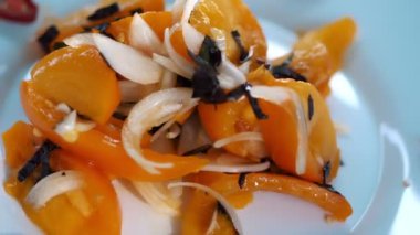 salad. cooking. close-up. chopped vegetables. freshly prepared salad of fresh yellow tomatoes, onions, fragrant basil and spices, and seasoned with vegetable oil