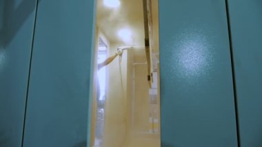 Airless Spray Painting. Industrial painting process at painting factory facility.