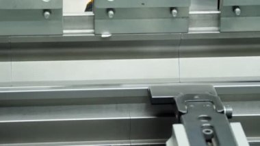 metal bending. close-up. metal sheet bending machine. hydraulic press brake for flat sheet metal. Metal working. Industrial manufacturing.