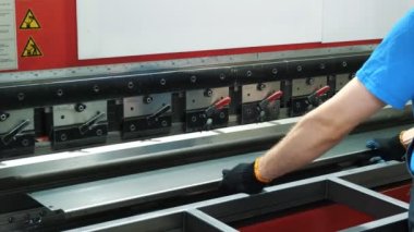 metal bending. The technician operator is working with hydraulic press brake bending machine at the factory. Industrial manufacturing.