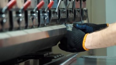 jig punch press. close-up. hydraulic press brake or bending machine for flat sheet metal. operator is working on bending sheet metal machine