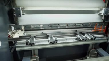 metal bending. close-up. metal sheet bending machine. hydraulic press brake for flat sheet metal. Metal working. Industrial manufacturing.