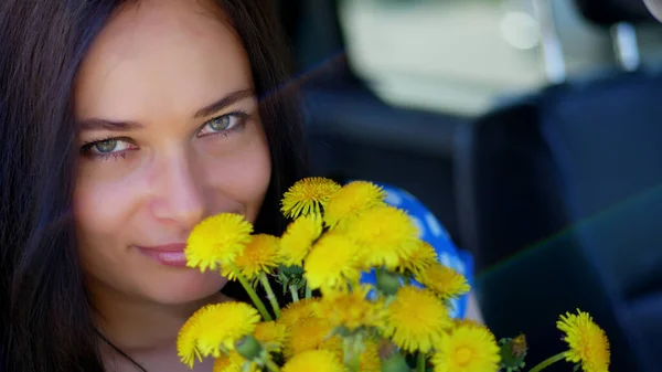 Portrait Beautiful Brunette Woman Sitting Car Bouquet Yellow Dandelions Smiling — Stockfoto