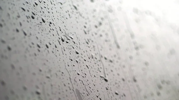 close-up, on the car glass windows rain drops drip down a multitude of streams. its raining heavily, downpour. raindrops on the car glass. High quality photo