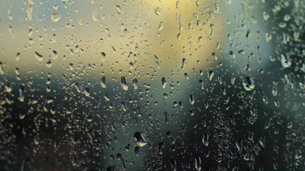 close-up, on the glass there are large drops of rain, water, drops of water on a glass structure, surface. colorful glass, background. High quality photo