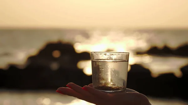 Склянка Води Заході Сонця Крупним Планом Силует Жіночої Руки Тримає — стокове фото