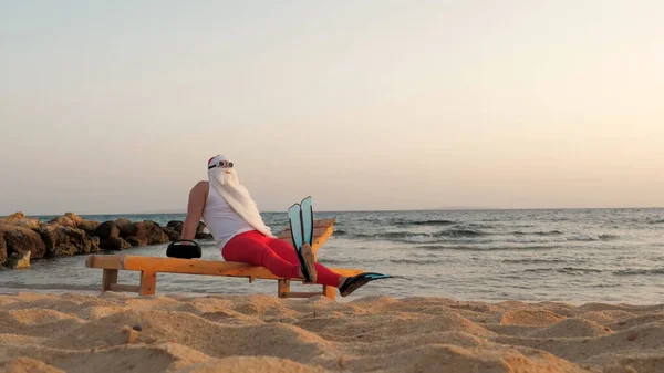 재미있는 클로스는 햇빛을 받는다 선글라스와 오리발을 산타는 라운지에 해변에서 음악을 — 스톡 사진