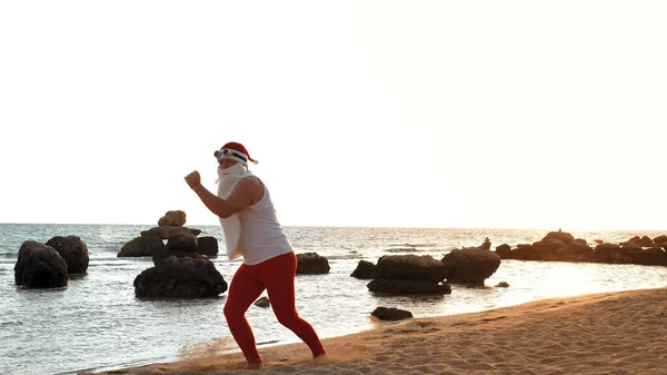 Grappige Kerstman Kerstman Doet Ochtendoefeningen Kerstman Danst Het Strand Aan — Stockfoto
