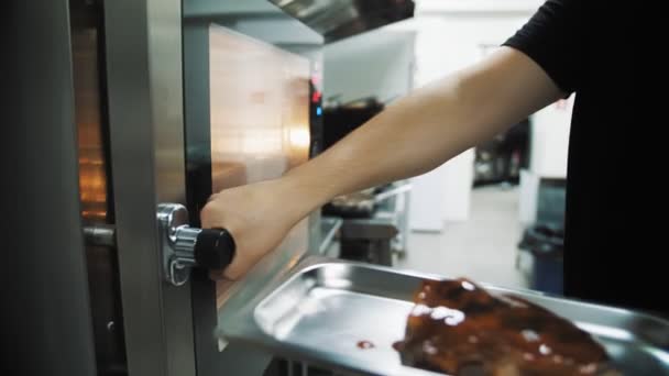 烤箱里的肉 厨师在烤箱里烤一块肉 在烤盘上用酱汁做的肋条 在餐馆做饭 — 图库视频影像
