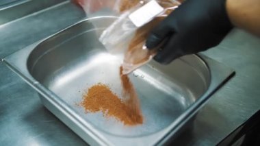 Baharatlar. baharat karışımı. Bitkiler. Yakın plan. Aşçı, metal bir kaba baharat ve baharat karışımı döker. Et pişirmek için baharatlar ve baharatlar.