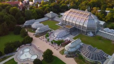 Seralar, seralar. İnanılmaz hava görüntüsü uçuş panorama yörüngesi drone görüntüleri botanischer garten Berlin Lichterfelde, altın saat yaz 2022 4k Sinema