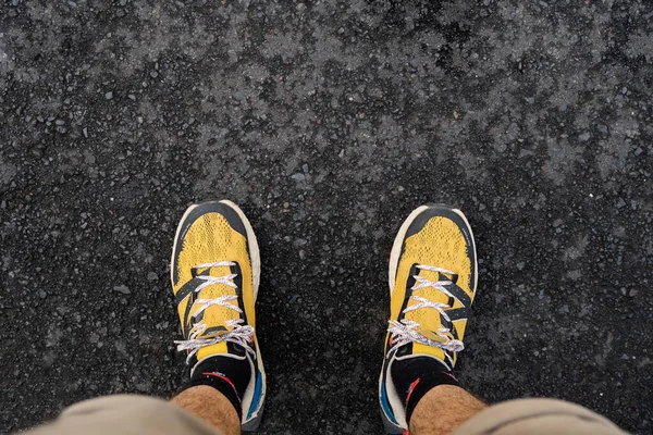 Man with shorts pants wear yellow running shoes on asphalt road